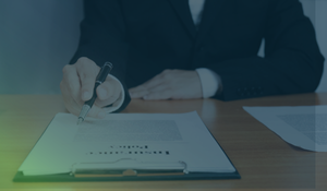 Business owner reviewing and signing a cyber insurance policy at a desk.
